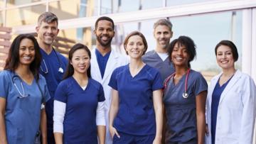 Doctors, nurses and other health workforce members standing together