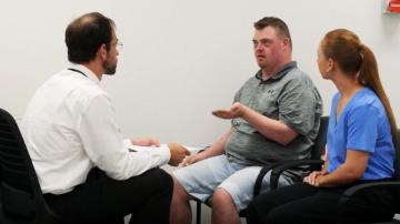 Doctor patient and support worker talking together