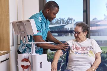 A care worker assists an elderly resident
