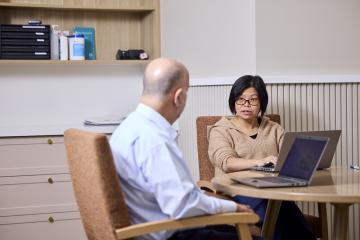 RN sitting at a table discussing handover process