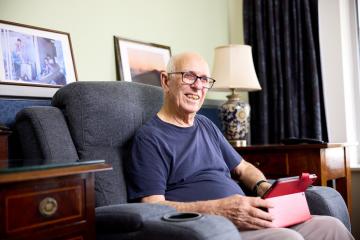 Elderly man sitting in a recliner with an iPad