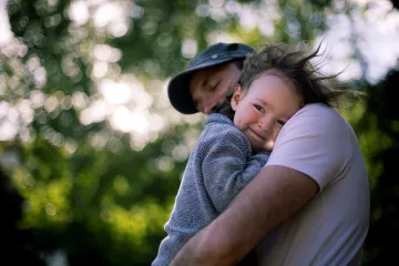 Male cuddling small child