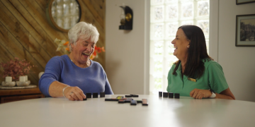 Two women having a laugh at the dining table