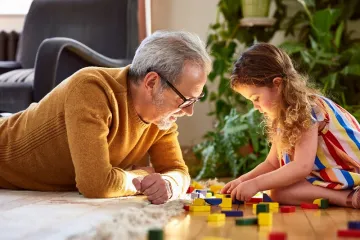 male father with his young daughter playing with blocks
