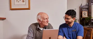 Photograph of an elderly male talking to a male carer