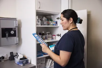 Nurse looking at a blister package with medication