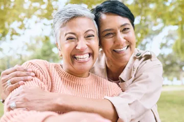 Two people embracing with trees in the background