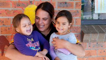 Female indigenous health worker with two children