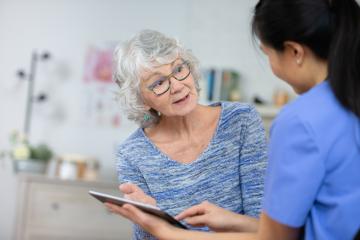 Elderly woman and doctor with tablet
