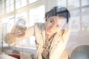 Woman writing on a clear whiteboard