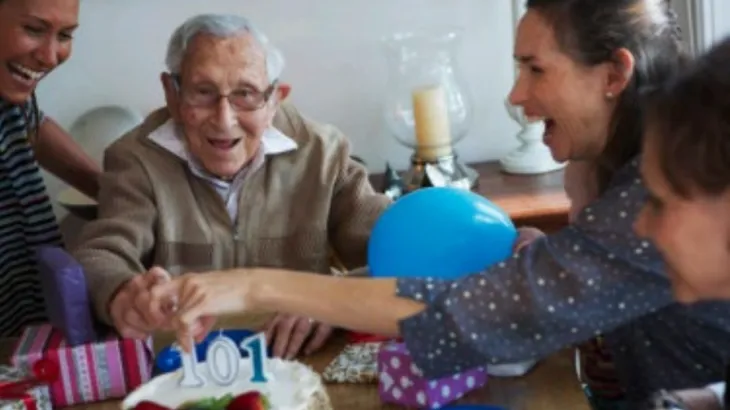 Grandfather surrounded by his family around the table