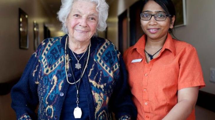 Older person and carer in corridor