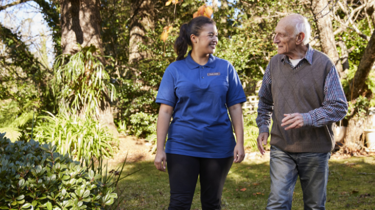 Health worker walking with elderly man