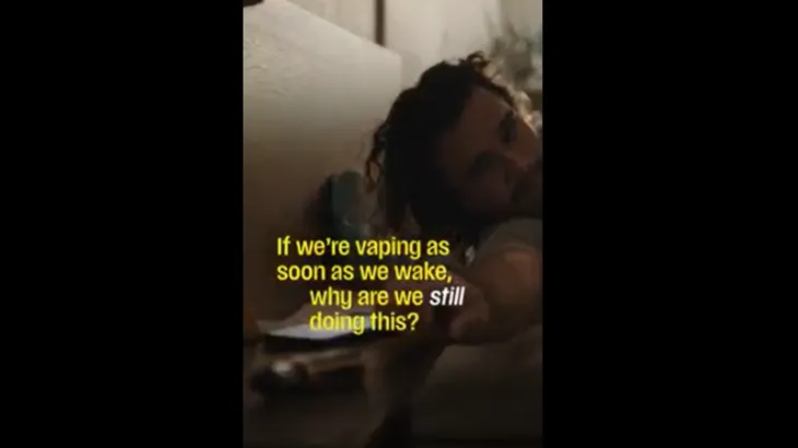 Man reaching for a vape from bed