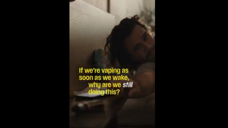 Man reaching for a vape from bed