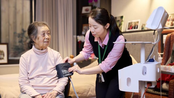 Aged care nurse taking the blood pressure reading of an aged care resident