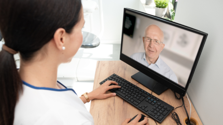 Virtual nursing in aged care: A nurse using her computer to communicate with a patient