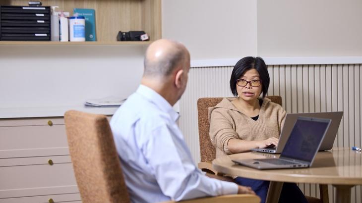 RN sitting at a table discussing handover process
