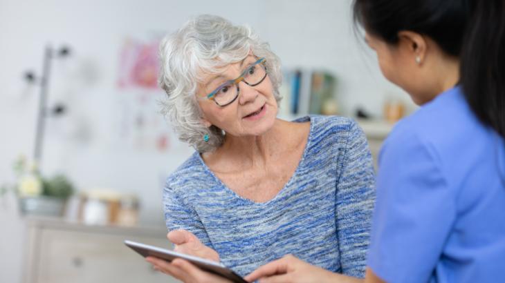 Medical nurse discussing results with elderly patient