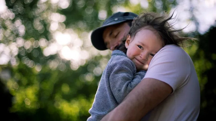Male cuddling small child
