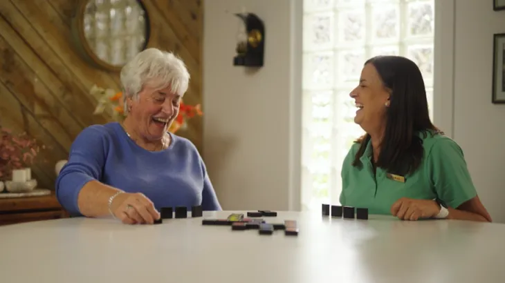 Two women having a laugh at the dining table