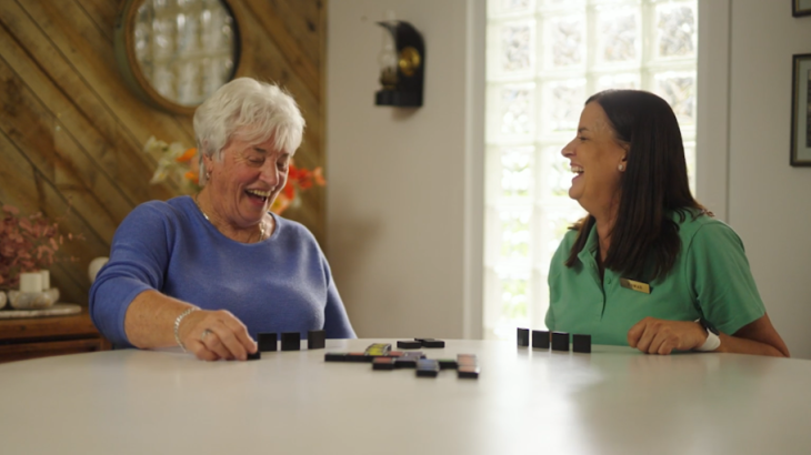 Two women having a laugh at the dining table