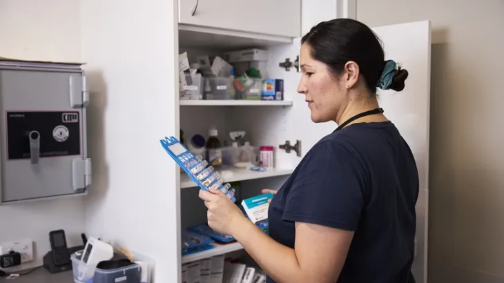Nurse looking at a blister package with medication