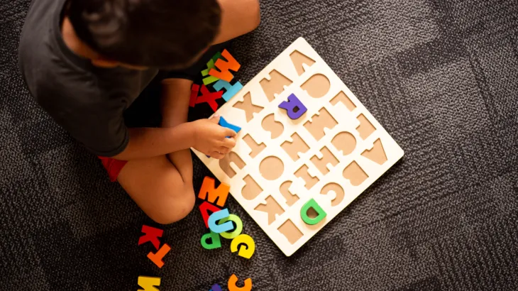 A child playing with a puzzle board
