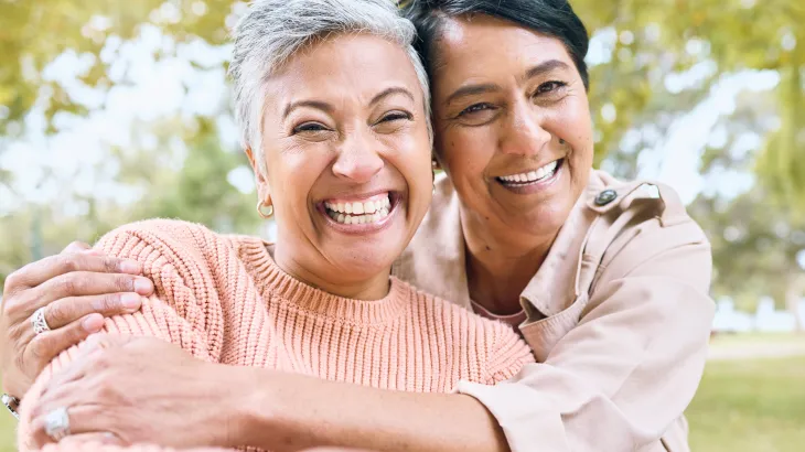 Two people embracing with trees in the background