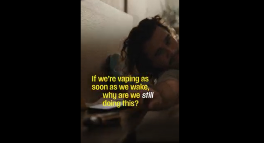 Man reaching for a vape from bed