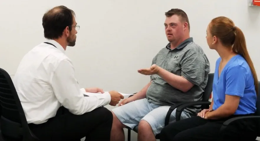 Doctor patient and support worker talking together