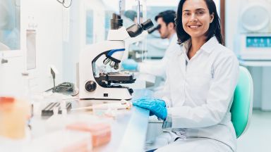 Young female scientist at work - male scientist in background
